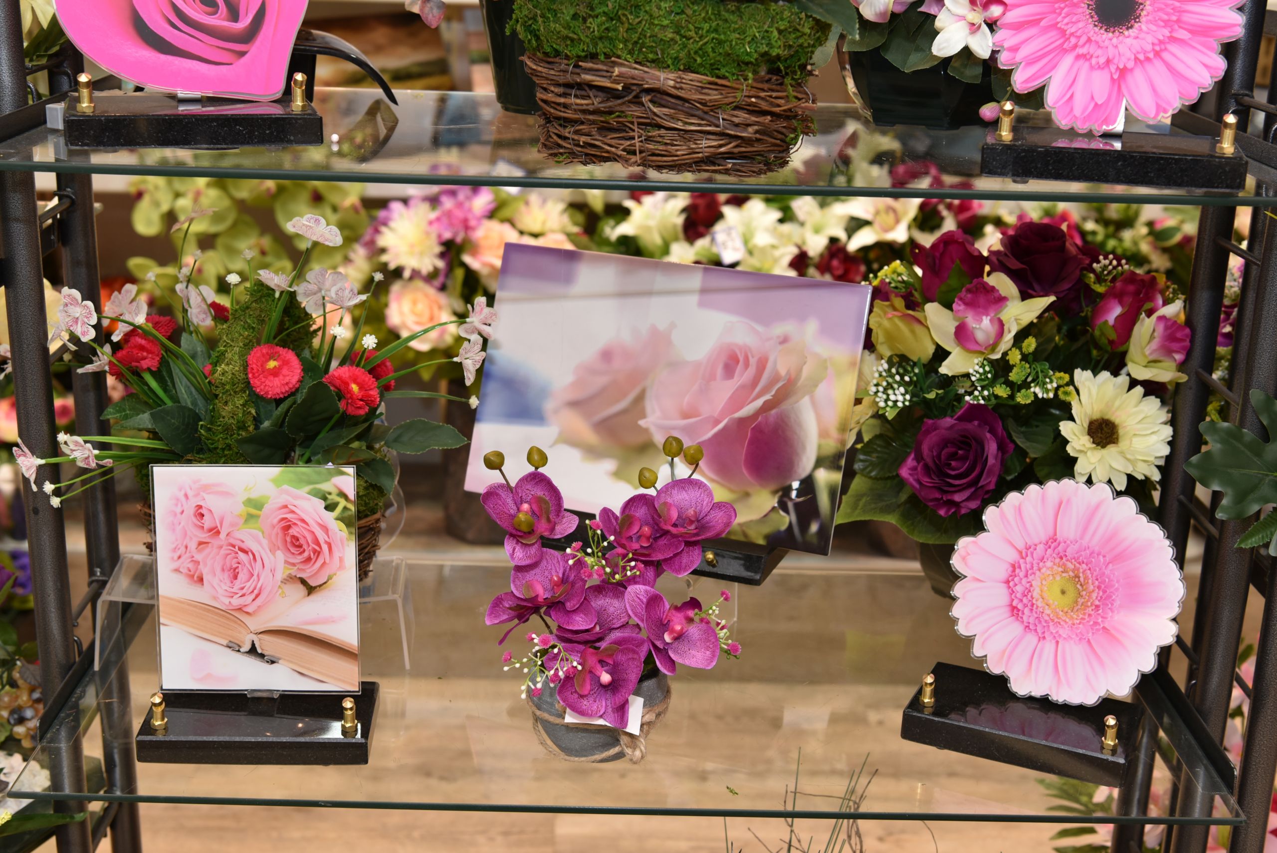 Pompes funèbres Pinault à Lyon, Miribel, Rillieux et Neuville. Articles funéraires en vitrine dans les tons de rose. Plaques souvenir et ouvrages de fleurs deuil.